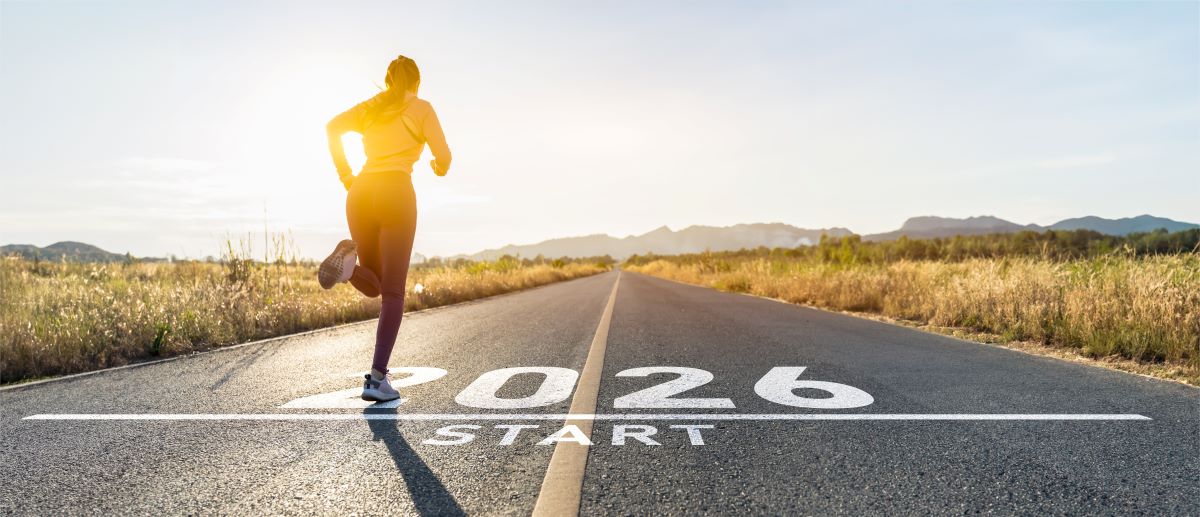 Eine Frau beginnt ihren Lauf an einer Linie die mit 2026 und Start beschriftet ist